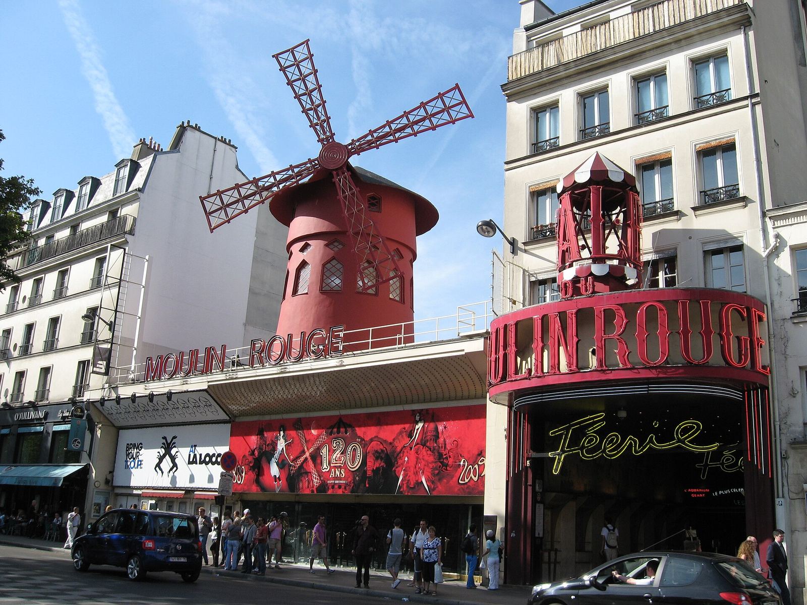 The illuminated red windmill of the Moulin Rouge cabaret at dusk